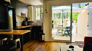 Una cocina compacta con encimera de madera, un refrigerador negro y un lavamanos.