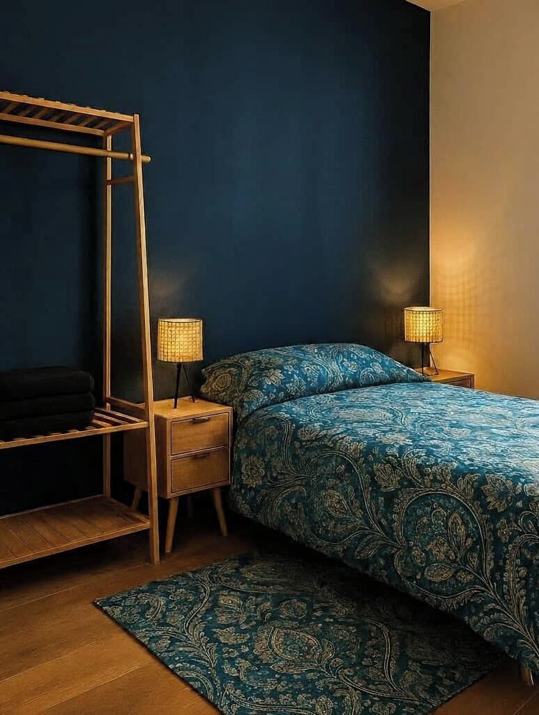 Ein Schlafzimmer mit einem Etagenbett, zwei Nachttischen inklusive Lampen, einer gemusterten Bettdecke und einem passenden Teppich.