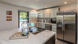 Una cocina moderna con un refrigerador de acero inoxidable, un lavavajillas y una cafetera.