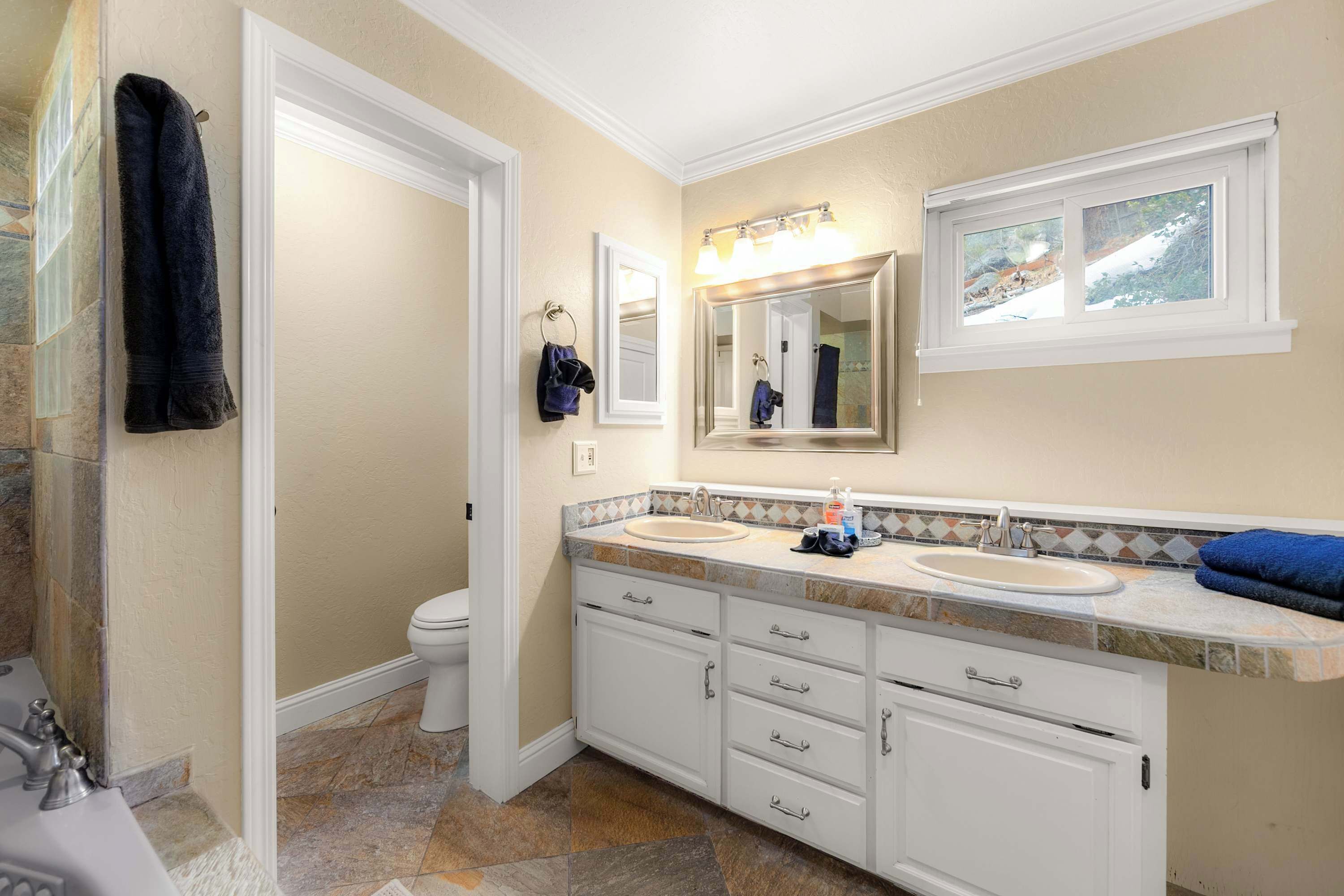 A bathroom with two sinks, a toilet, and a shower.