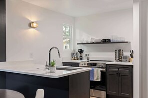 A modern kitchen with a central island, stainless steel appliances, and a built-in oven.