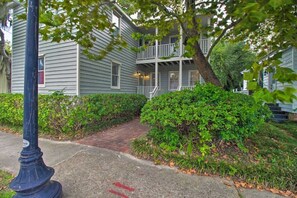 A two-story building with a covered front porch and a brick pathway leading to the entrance. - New Downtown 2bd w. Modern Southern Charm (Beaufort)