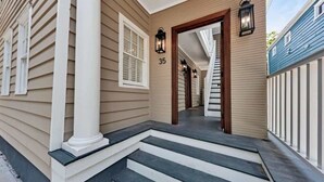 A house with a front porch, a staircase, and a number '35' on the wall. - Bright 2bd w. Chef's Kitchen, 1 Block to King! (Charleston)