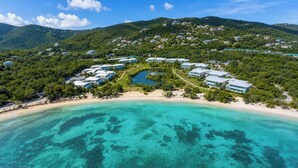 Ein Resort mit Strandhäusern, einer zentralen Wassereinrichtung und üppiger Bepflanzung.