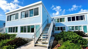 A modern two-story building with a staircase leading to the entrance. - OCEAN FRONT GENERATOR COMPELETION 11/1/2026 (East End)