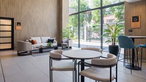 Un interior moderno con un sofá, sillas, una mesa redonda y una estación de café.