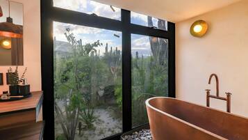 Een aparte badkuip en douche, handdoeken, zeep, shampoo