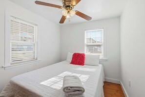 A bedroom with a bed, a ceiling fan, and two windows with blinds. - Lakefront Cottage #2 | Dock | Mtn & Lake Views (Bristol)