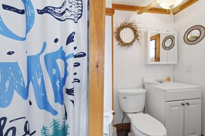 Un baño con inodoro, lavamanos y espejo.