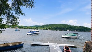 A calm lake with several boats docked at a wooden pier.