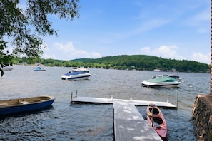 A calm lake with several boats docked at a wooden pier. - Lakefront Cottage #4 | Dock | Mtn & Lake Views (Bristol)