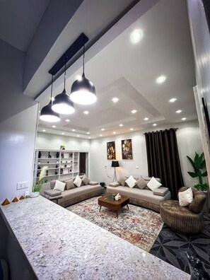 Una sala moderna con un sofá modular, una mesa de centro e iluminación colgante.