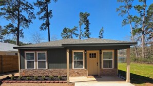 A single-story house with a gabled roof, a front porch, and a small front yard with a brick border. - Fabulous 4-bedroom 2.5 bath Lake Cottage (Montgomery)