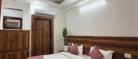 Un dormitorio con una cama de madera, un ventilador de techo y una mesita de noche con una planta.