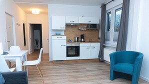 A compact living space with a kitchenette, a dining area, and a seating area. - Apartmenthaus am Park Wohnung 1 (Wilhelmshaven)