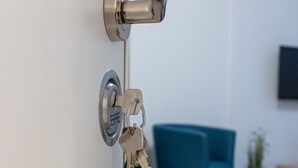 A door with a key lock, a key ring with keys, and a green key fob. - Apartmenthaus am Park Wohnung 1 (Wilhelmshaven)
