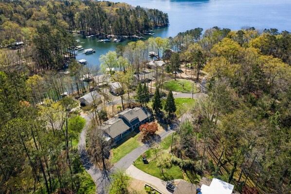 An aerial view of a residential area with houses, a lake, and boats.