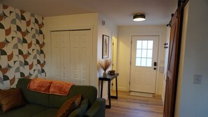 A living room with a green sofa, a patterned wall, and a wooden floor. - Walkability, centrally located, dog friendly (Redmond)