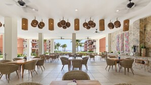 A spacious outdoor dining area with wicker furniture and hanging light fixtures.