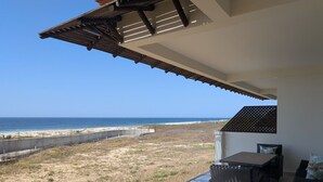 Ein Balkon mit Blick auf Strand und Meer.