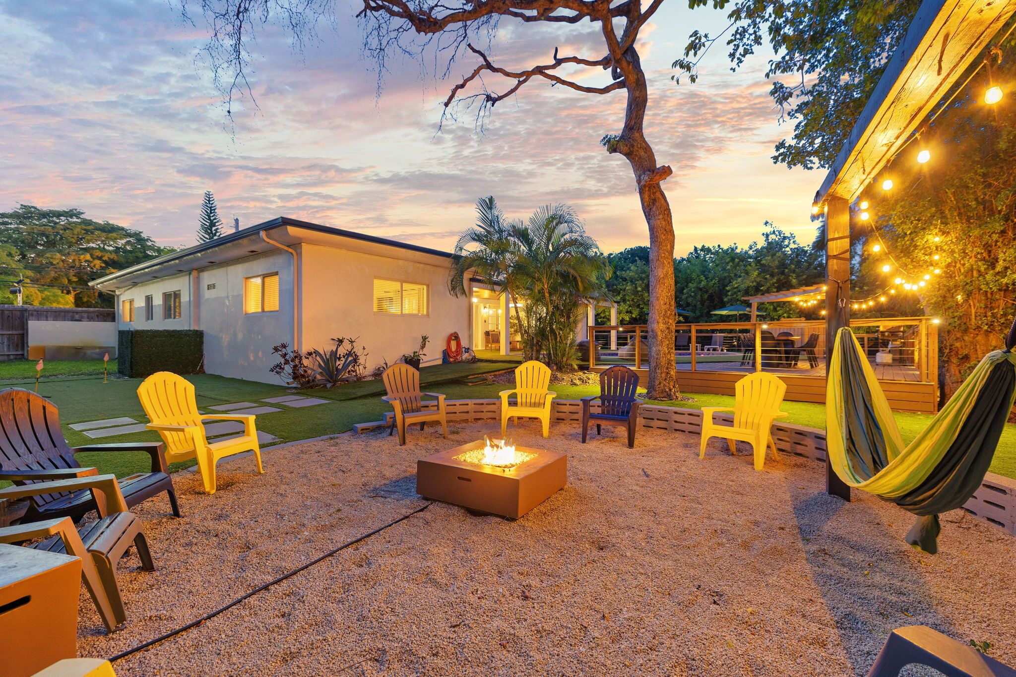 A patio with outdoor seating, a fire pit, and a hammock.