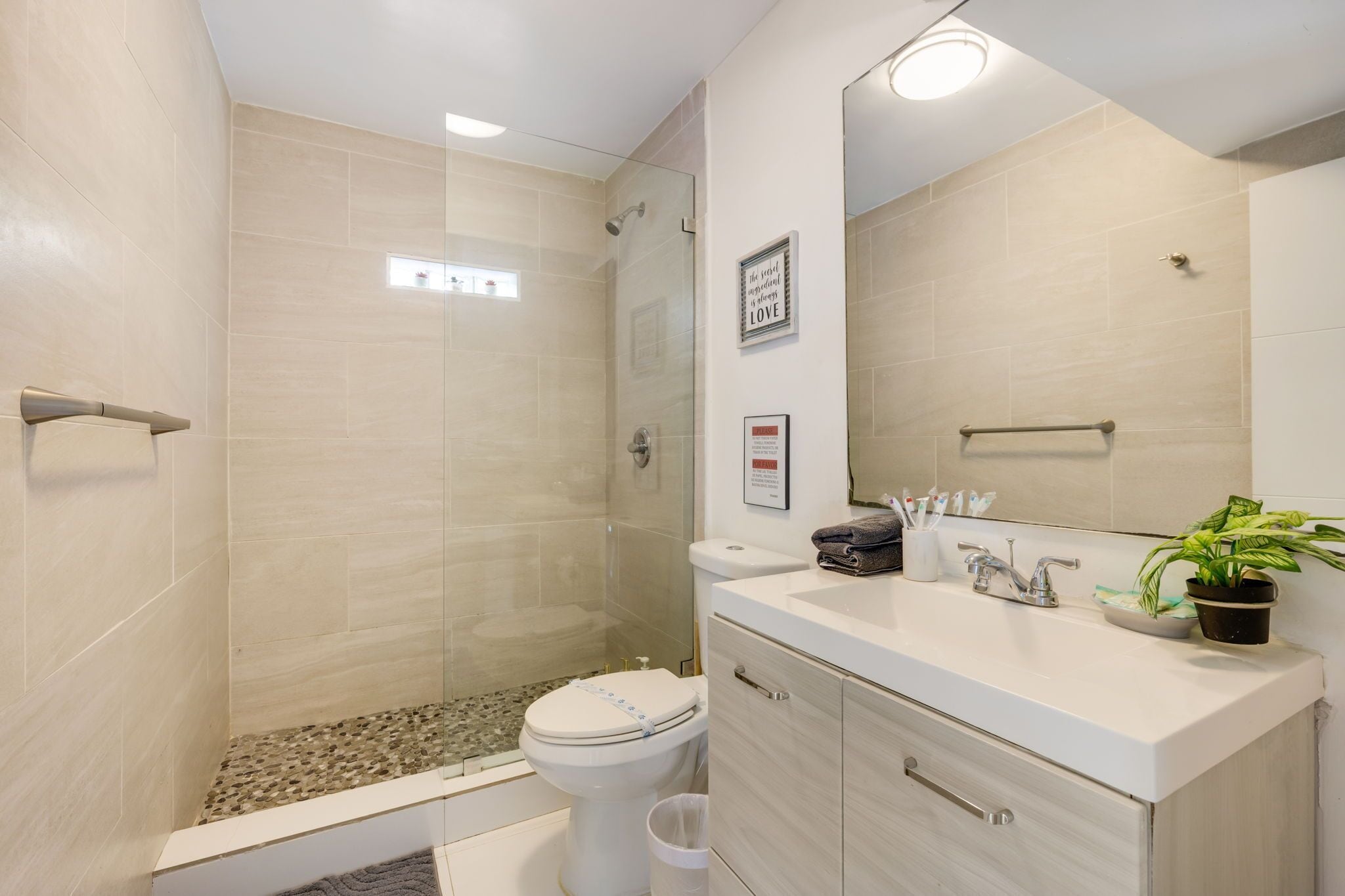 Une salle de bain moderne équipée d’une douche, de toilettes et d’un lavabo.