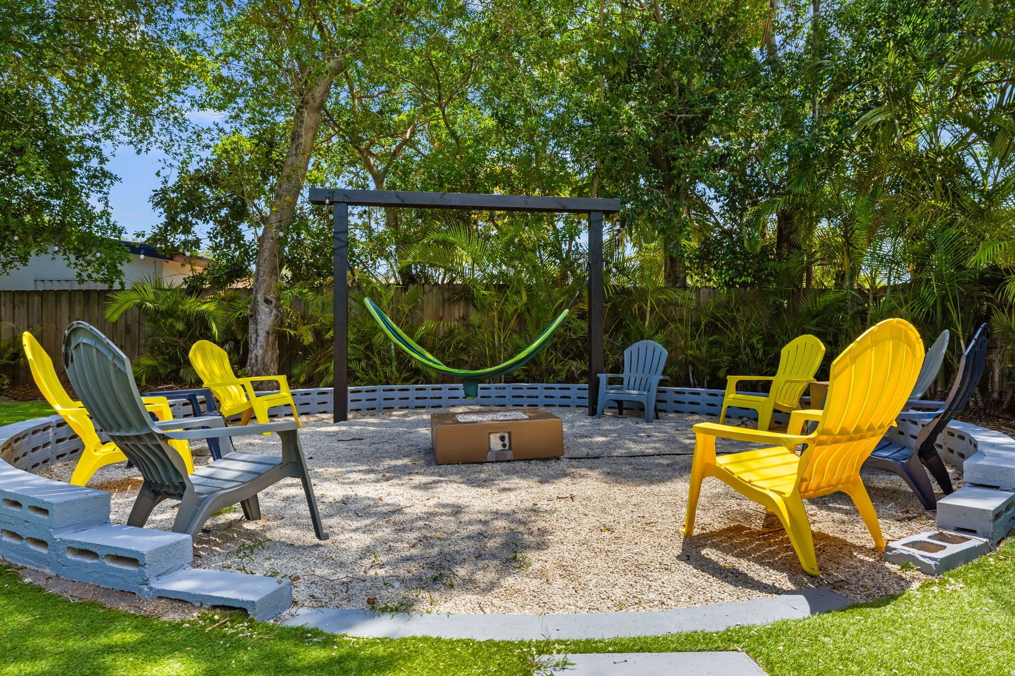 A circular outdoor seating area with chairs and a hammock.