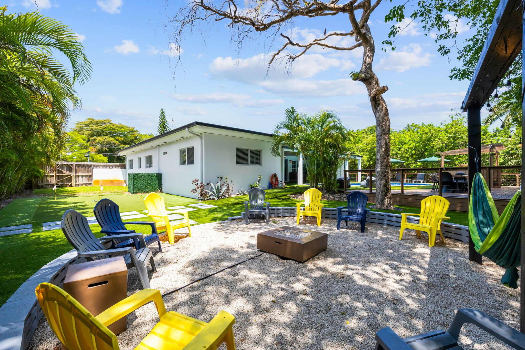 Eine Terrasse im Freien mit Sitzgelegenheiten, einem Feuerkorb und einem Haus im Hintergrund.