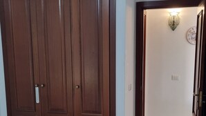 Ein Schlafzimmer mit großem Kleiderschrank, einem Bett und einem Flur, der in einen anderen Raum führt.