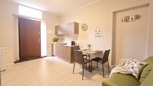 A modern apartment with a kitchen, dining area, and a living room. - Courtyard & Balconies (Como)