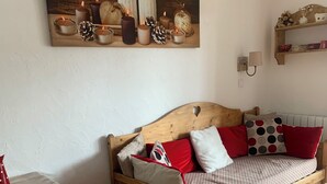 A cozy room with a wooden bed, a wooden table, and a painting above the bed. - 4/5-person apartment at the foot of the slopes (Risoul)