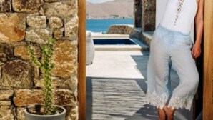 A stone wall and a wooden door leading to a pool area with a view of the sea. - Suite with Private Pool and sea view (Mykonos)