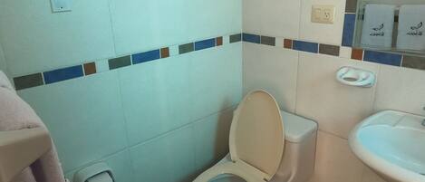 A small bathroom with a toilet, sink, and a towel rack.