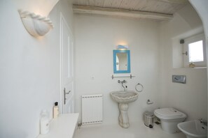 Une salle de bain avec un lavabo blanc, des toilettes et un miroir doté d’un cadre bleu.