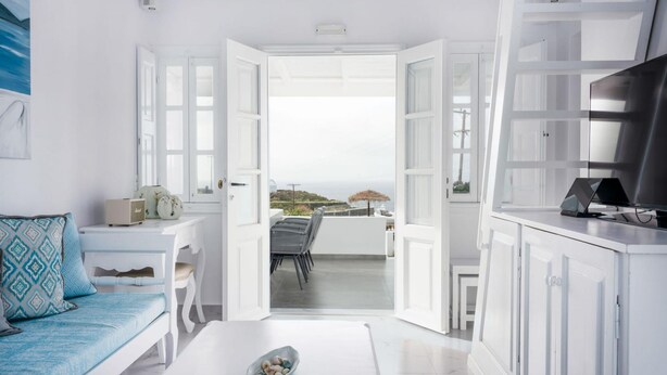 A modern, white-themed living room with a balcony overlooking a scenic landscape. - DIAMOND 4BD Villa Pool & HotTub Sea/Sunset View (Santorini)