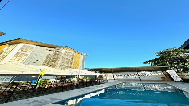 Una piscina con un edificio al fondo.