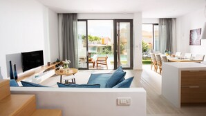 A modern living room with a TV, sofa, and dining area. - Opulent VILLA K on Crete (Galatas)