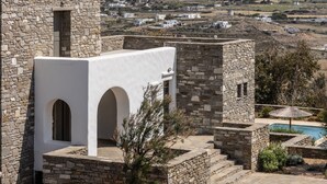 Ein Steinhaus mit Bogenfenstern und einem Poolbereich.