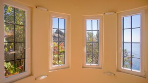 Una habitación con tres ventanas, cada una con vistas al exterior.