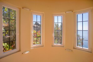 Ein Zimmer mit drei Fenstern, jedes bietet Blick ins Freie.