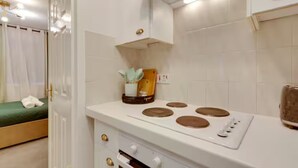 Cocina compacta con estufa, horno y una pequeña encimera.