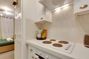 A compact kitchen with a stove, oven, and a small countertop. - Stylish and modern studio flat | Free parking - Pass the Keys (Cambridge)
