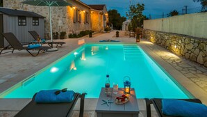 Une piscine équipée de chaises longues et d’une table avec des accessoires.