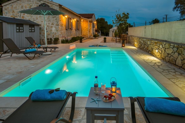 Une piscine équipée de chaises longues et d’une table avec des accessoires.