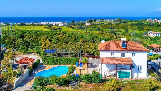 Eine Villa mit Swimmingpool, Solaranlage und Meerblick.