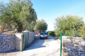 A stone-walled driveway leading to a parked car. - Antigoni Villa Ena in Longos (Longos)