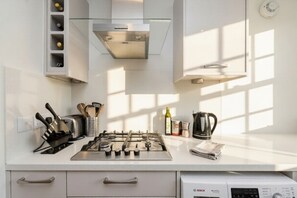 A modern kitchen with a gas stove, built-in cabinets, and a Bosch dishwasher. - [Superhost] 12 mins walk to Buckingham Palace & Big Ben - Cozy 2BR Family Rental (London)