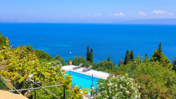A pool with a view of the sea, surrounded by greenery and trees. - Antigoni Villa Tria in Longos (Longos)