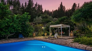 A swimming pool with lounge chairs and a gazebo in a landscaped garden. - Villa Sevi in Loggos (Paxi)