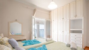 A hotel room with two beds, a large wardrobe, a mirror, and a view of the outside. - Villa Calypso in Nisaki (Nisaki)